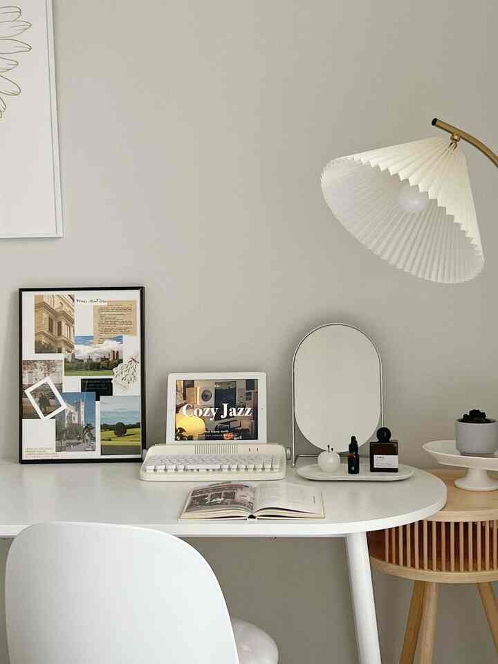 白とライトブラウンの木目調が調和するホームオフィス空間、丸テーブルと鏡、キーボードがすっきりと配置されたシンプルなデスク