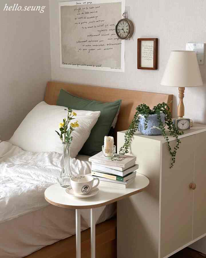 Natural wood tone and white bedroom featuring side table and plants creating a cozy atmosphere