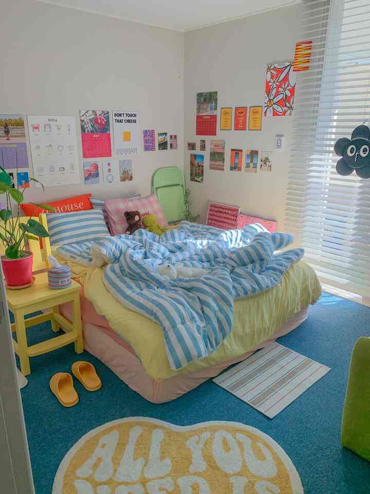 A bright and cozy studio bedroom in blue and yellow tones featuring a bed and wall decor