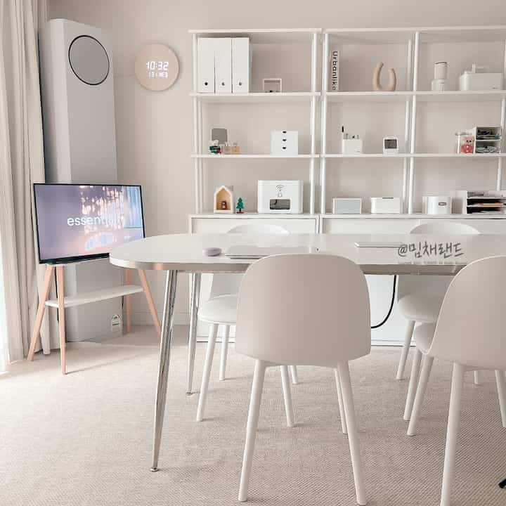 白を基調としたリビング兼書斎、ダイニングチェアとテーブルが配置された清潔感のあるモダンな空間