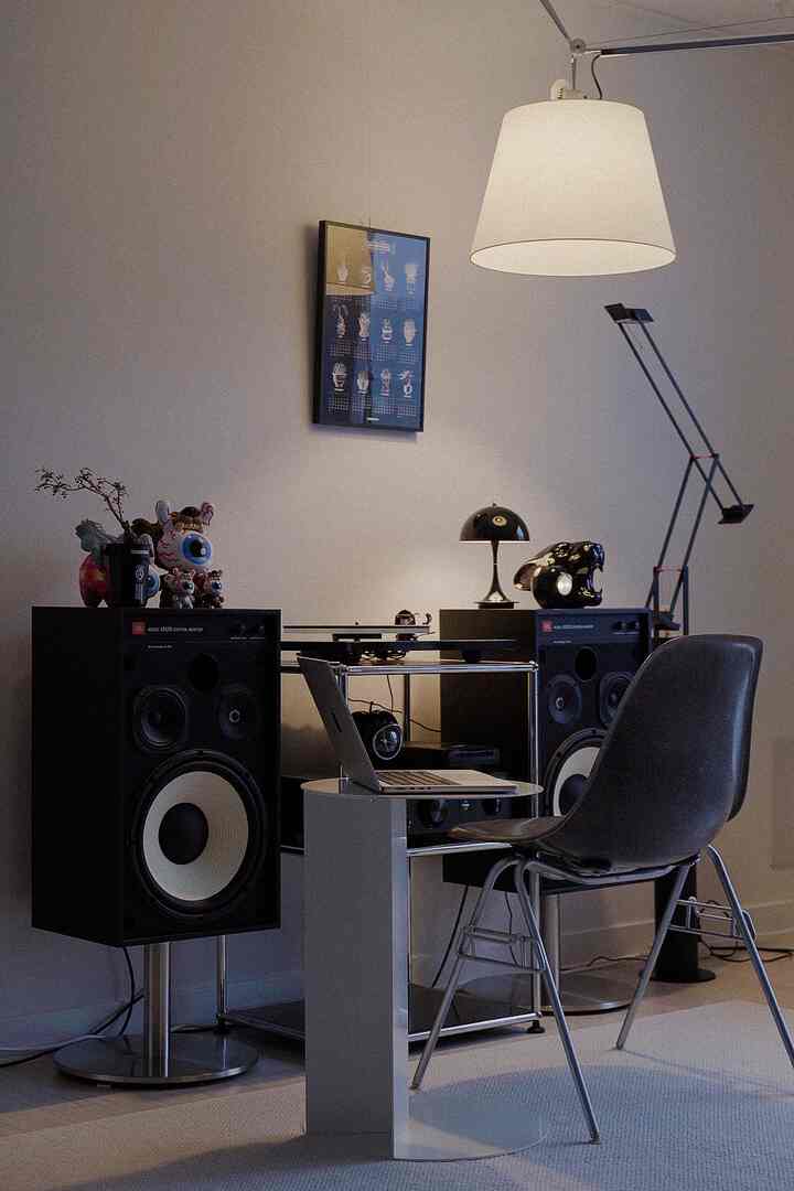 モノトーンの音楽鑑賞空間、大型スピーカーとターンテーブル、机が配置された雰囲気のあるインテリア