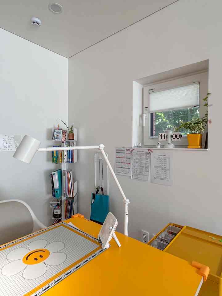 明るい黄色のデスクと白い壁が印象的な子供用の学習部屋