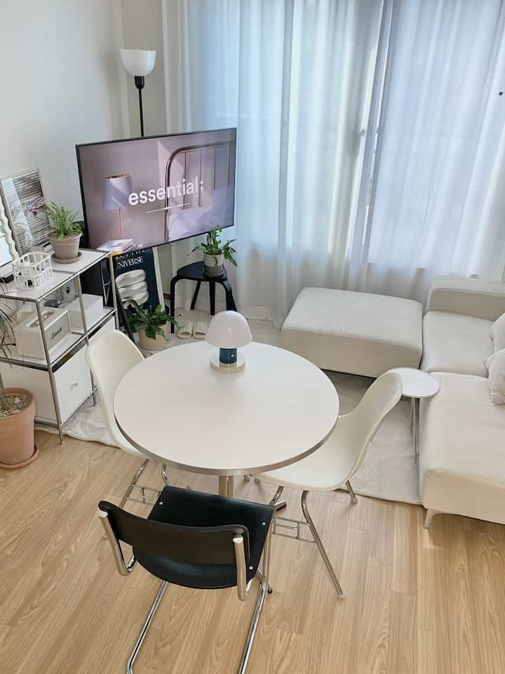 ホワイトと木目調が調和するリビング、丸テーブルとソファが配置された雰囲気のあるナチュラルモダンな空間