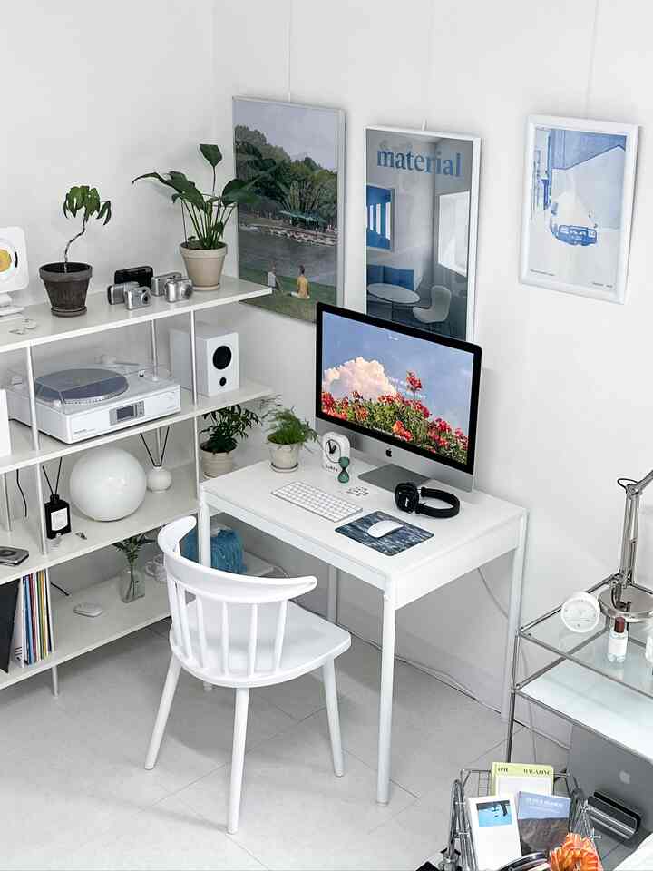 ホワイトトーンのコンパクトなホームオフィス、シンプルモダンなインテリアに小さなデスクとチェア、ポスターと植物が配置された空間