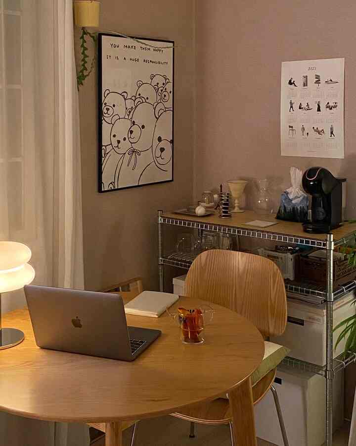 暖かいベージュトーンのベランダ空間、丸い木製テーブルと金属ラック、コーヒーマシンとポスターが配置された雰囲気のあるおうちカフェインテリア