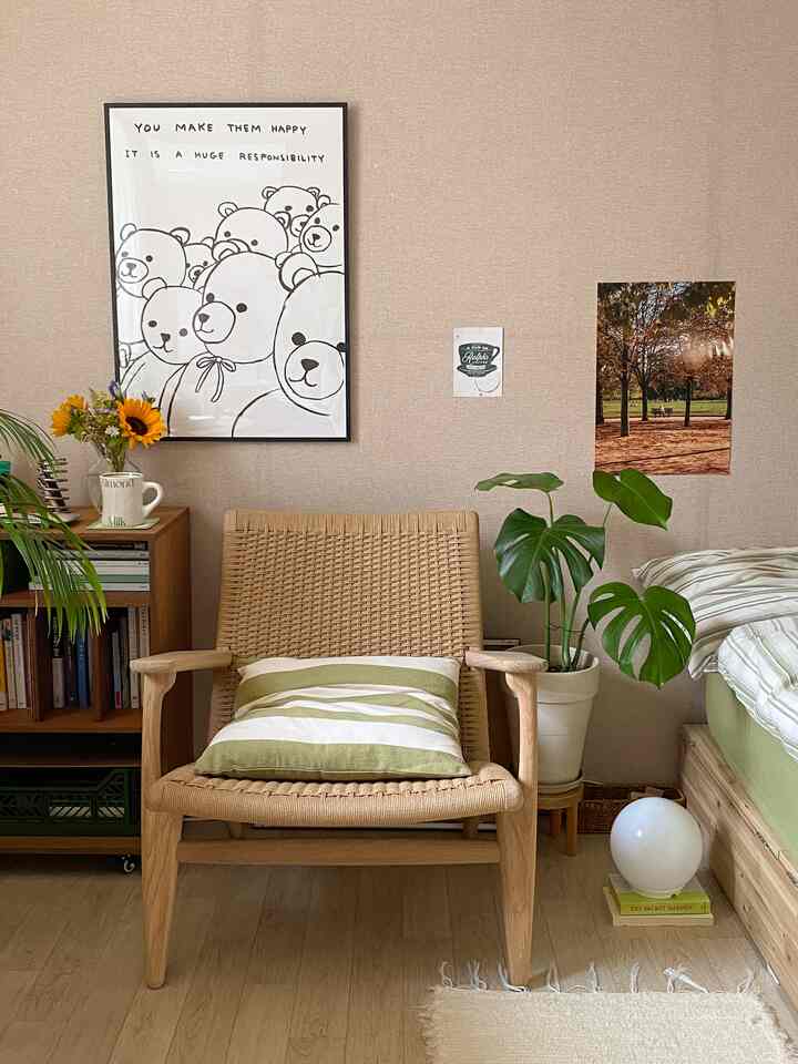 ベージュの壁とナチュラルな木目調が調和した空間、中央にアームチェアとストライプクッションが配置された温かみのあるインテリア