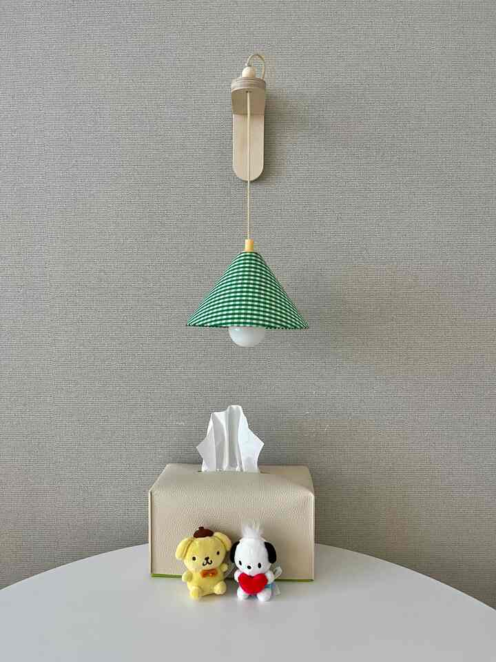 ベージュの壁とテーブルに緑のチェック柄ミニライトと小さなぬいぐるみが並ぶシンプルなインテリア