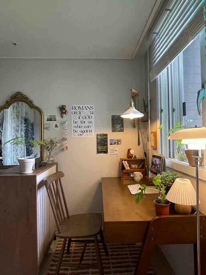 ナチュラルな木目調の壁と窓際のホームオフィス空間、デスクとチェア、植物が調和した雰囲気のあるインテリア