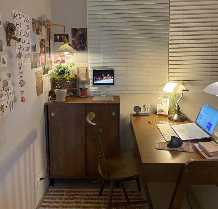 温かみのある木目調のホームオフィス空間、引き違い戸収納とデスク、ブラインドが配置された落ち着いた作業室