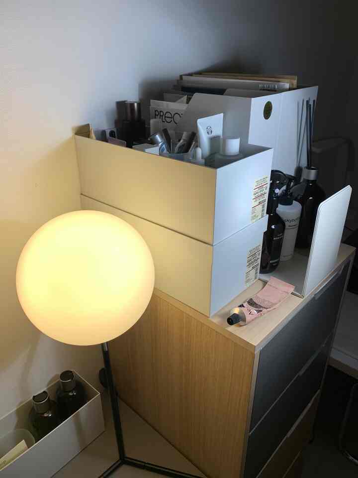 白とナチュラルカラーの狭いお手洗い、無印良品の収納ボックスとテーブルランプが配置された雰囲気のあるインテリア