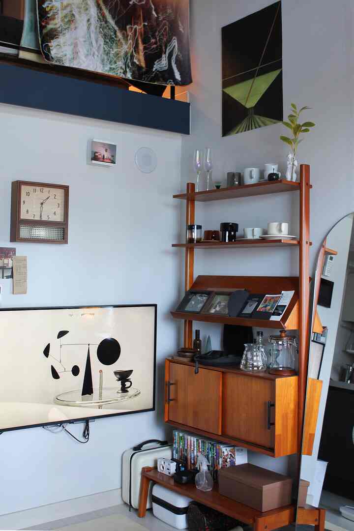 暖かみのある木目調と白い壁のリビング空間、壁掛けテレビと木製キャビネットが配置されたモダンでナチュラルなインテリア