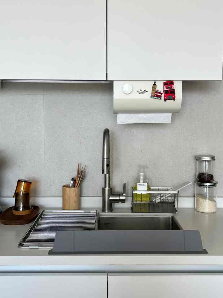 白とシルバーのトーンのキッチン、シンクとモダンな収納アイテムが整然と配置された雰囲気のあるインテリア