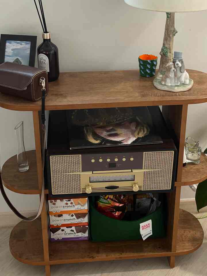 木目調の収納棚とヴィンテージスピーカーが配置されたリビング、照明と花瓶、キャンドルが温かみのある雰囲気を演出