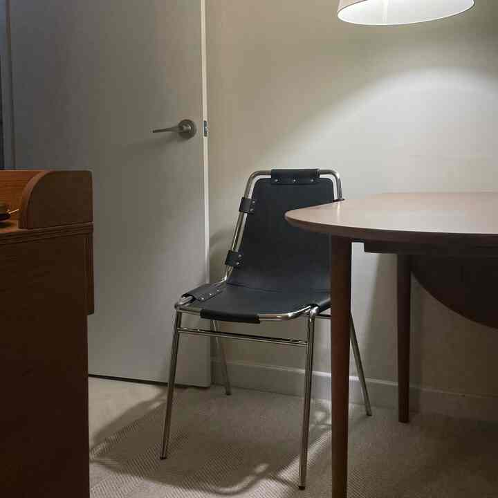 ブラウンの木目調とブラックのヴィンテージダイニングチェアが配置された落ち着いたダイニング空間