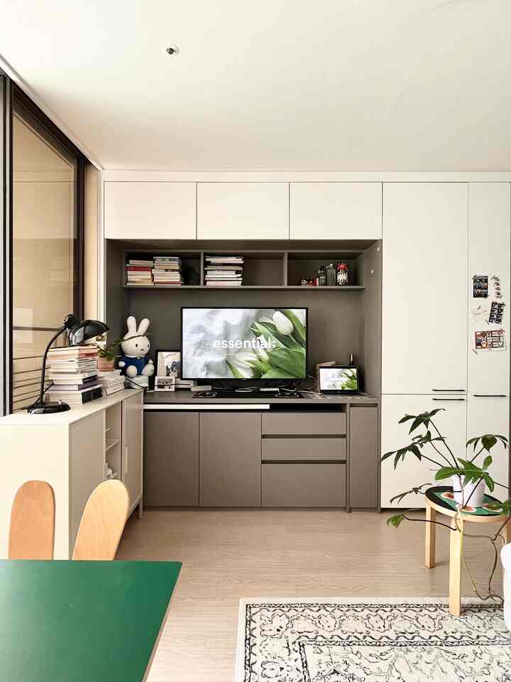 グレーとホワイトのモノトーンのビルトイン収納が配置された一人暮らしのリビング、テレビと小物が整った雰囲気のあるインテリア