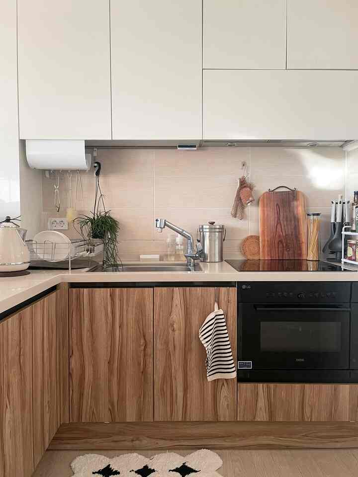 ナチュラルな木目調とホワイトが調和したキッチン、整頓された調理スペースと小物が配置された雰囲気のあるインテリア