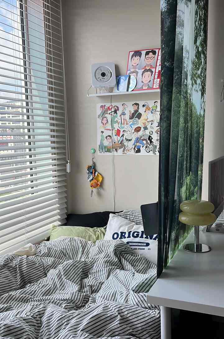 ナチュラルカラーとホワイトトーンの寝室、ストライプ柄の掛け布団カバーと枕が配置された居心地の良い空間