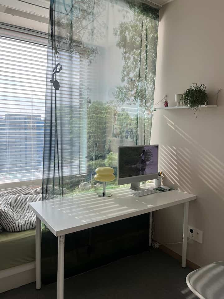 白とベージュの色調のモダンなホームオフィス、広いデスクとパソコンが配置された清潔感のある空間