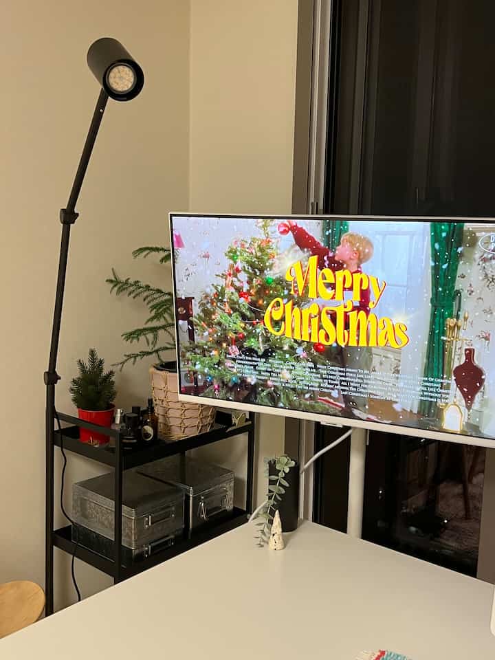 明るいホワイトとブラックのトーンのウォークインクローゼット、白いデスクと黒のキッチンワゴンに植物とテーブルランプが配置された清潔感のあるインテリア