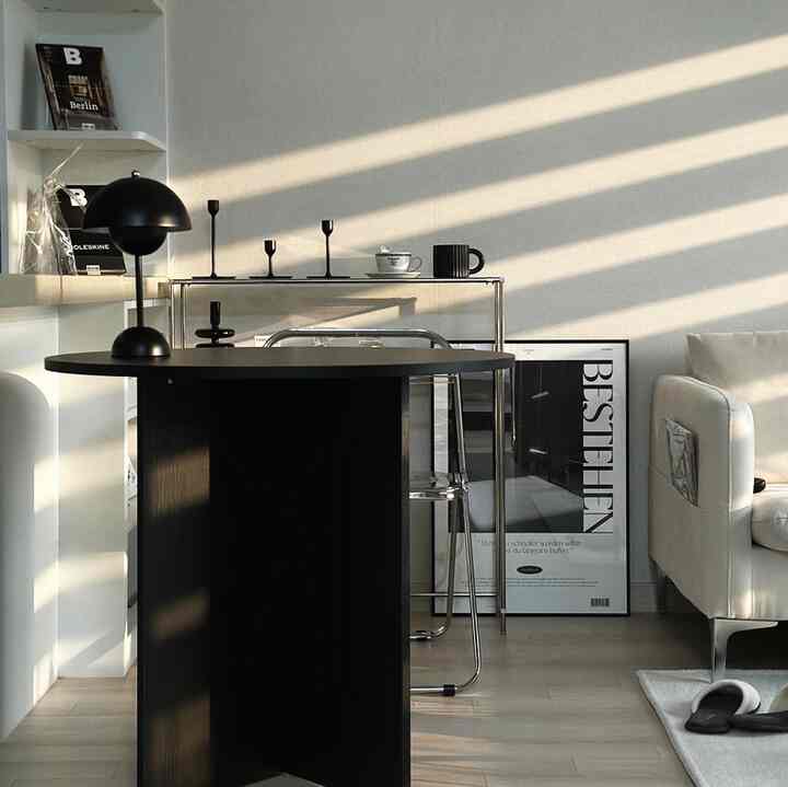 白と黒のトーンのリビング、モダンなテーブルとアームチェアが配置された落ち着いた雰囲気のインテリア