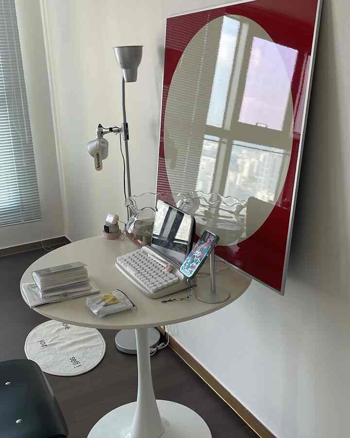 ホワイトとブラウンのトーンでまとめられたコンパクトなホームオフィス、丸いデスクとオフィスチェアが配置されたすっきりとした作業空間