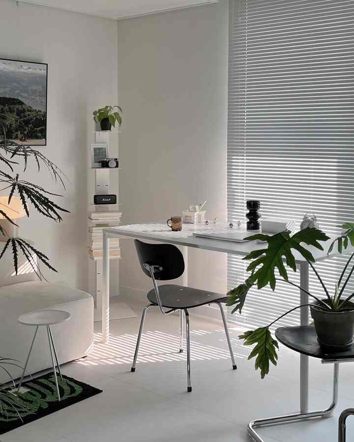 白と黒のトーンが調和したリビング、モダンなテーブルと椅子が配置されたシンプルで自然な雰囲気のインテリア