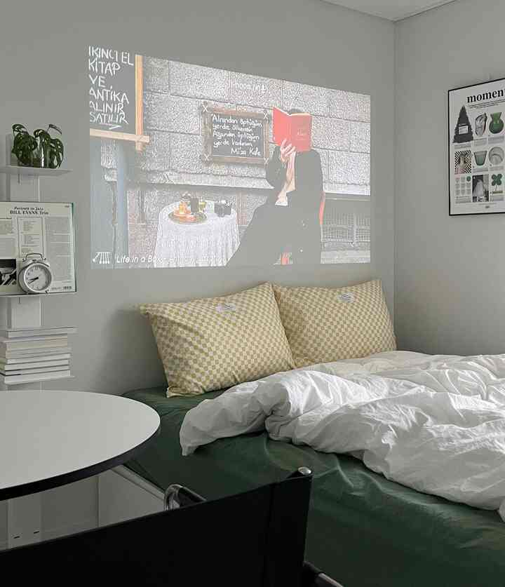 白と緑の調和した寝室、寝具と枕が配置されたシンプルモダンな雰囲気のインテリア