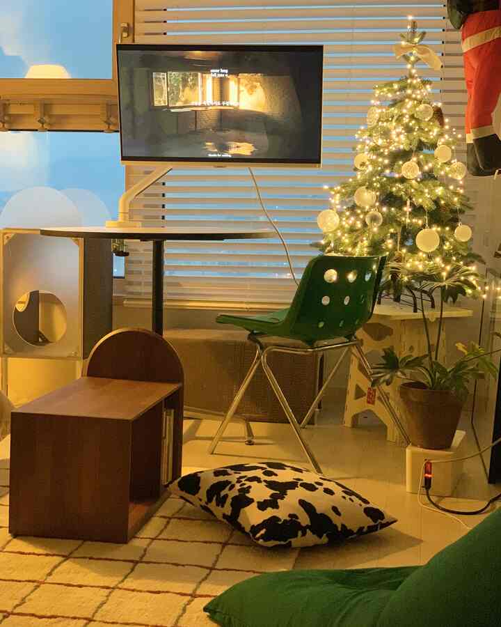 ホワイトと木目調のリビング、キャットタワーとクリスマスツリーが温かみのある雰囲気を演出するミッドセンチュリーモダンスタイルの空間