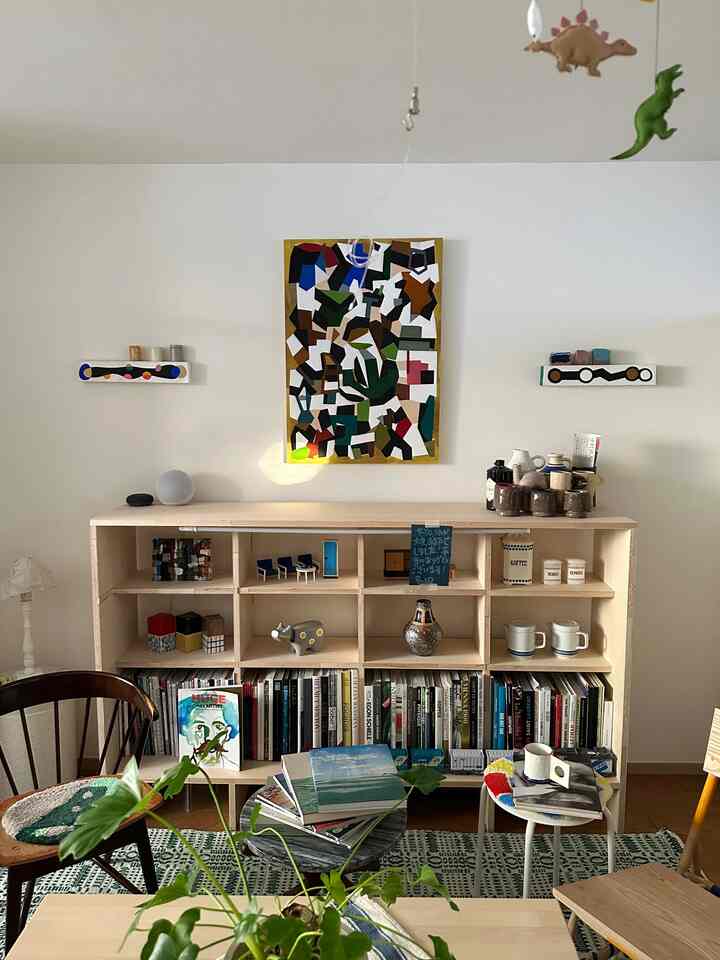 ナチュラルモダンスタイルのリビング、中央に本棚と植物が配置された居心地の良い空間