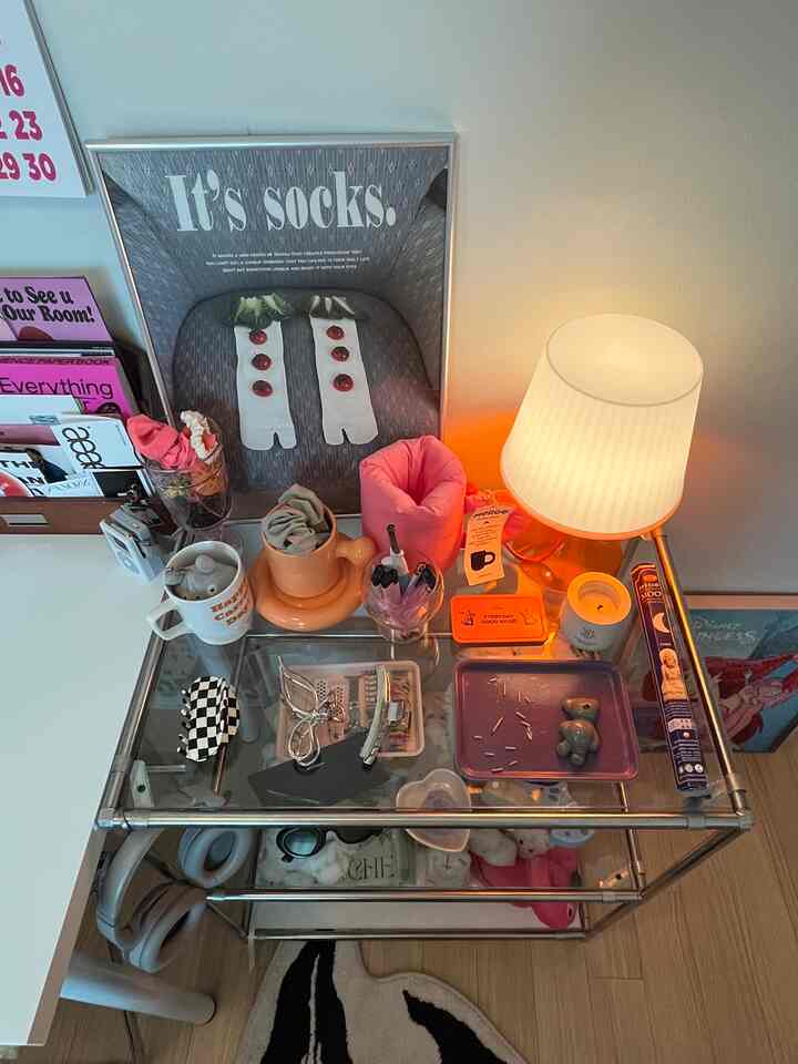 ナチュラルカラーの空間、モジュール式の棚に様々な小物とテーブルランプが置かれ、実用的で落ち着いた雰囲気のインテリア