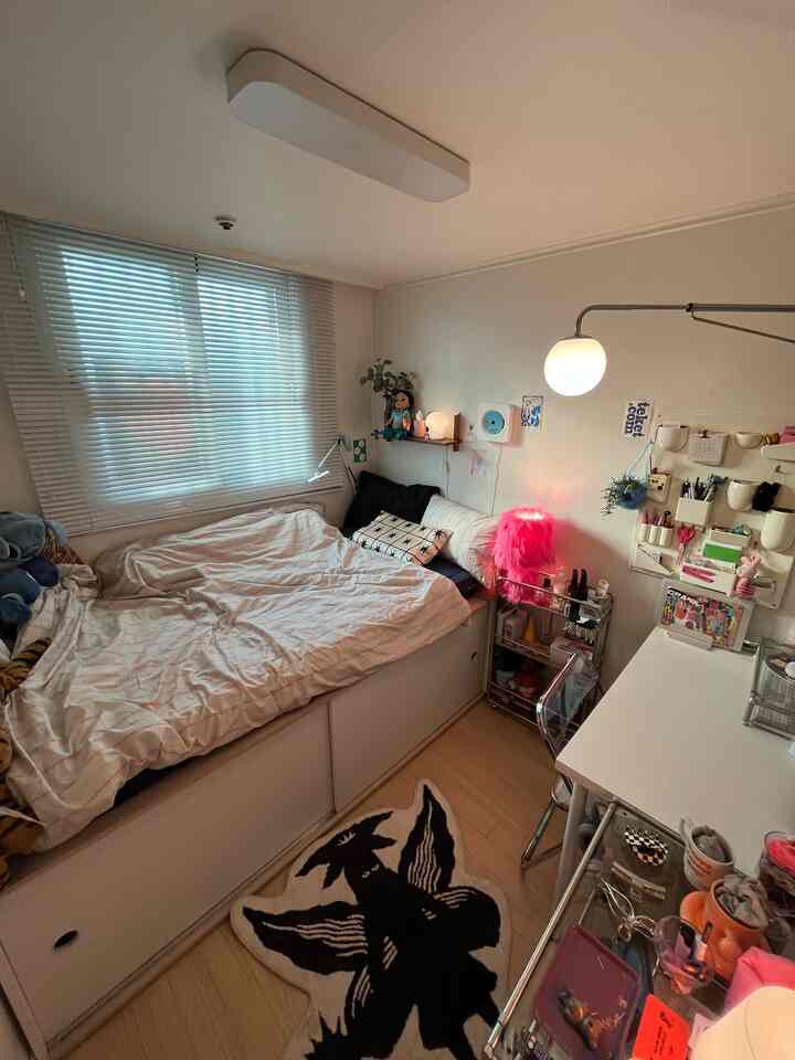 白とナチュラルカラーのコンパクトな寝室、ベッドとデスクが配置された効率的な空間