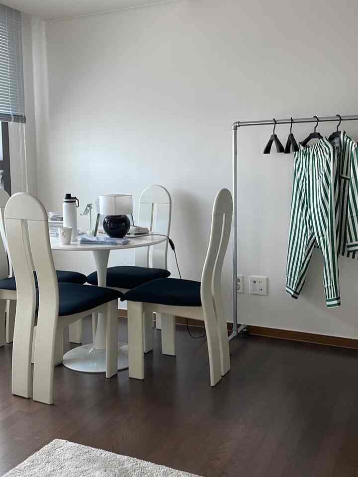 白と黒のトーンでまとめられたモダンダイニングルーム、丸テーブルと4脚の椅子が配置されたシンプルな空間