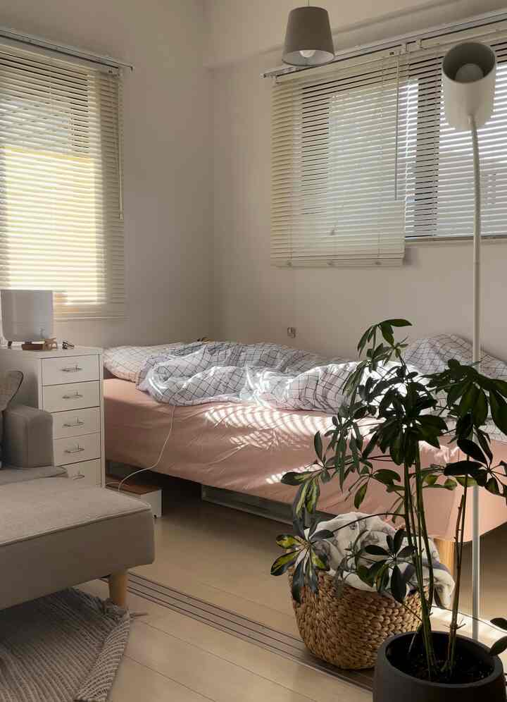 ベージュとナチュラルな色調の寝室、ベッドとチェストが配置された落ち着いた空間