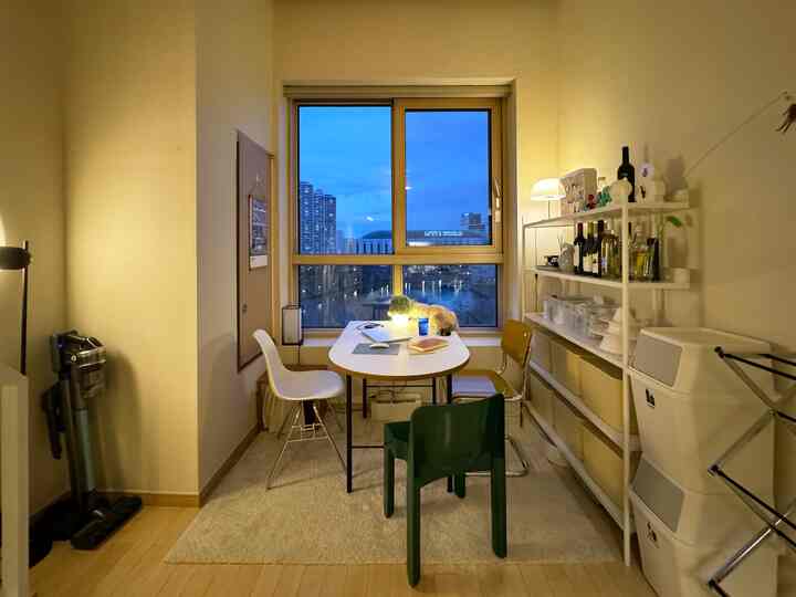 ホワイトとブラウンのトーンが印象的なコンパクトな2人用キッチンダイニング空間、窓際に猫が座る雰囲気のあるインテリア