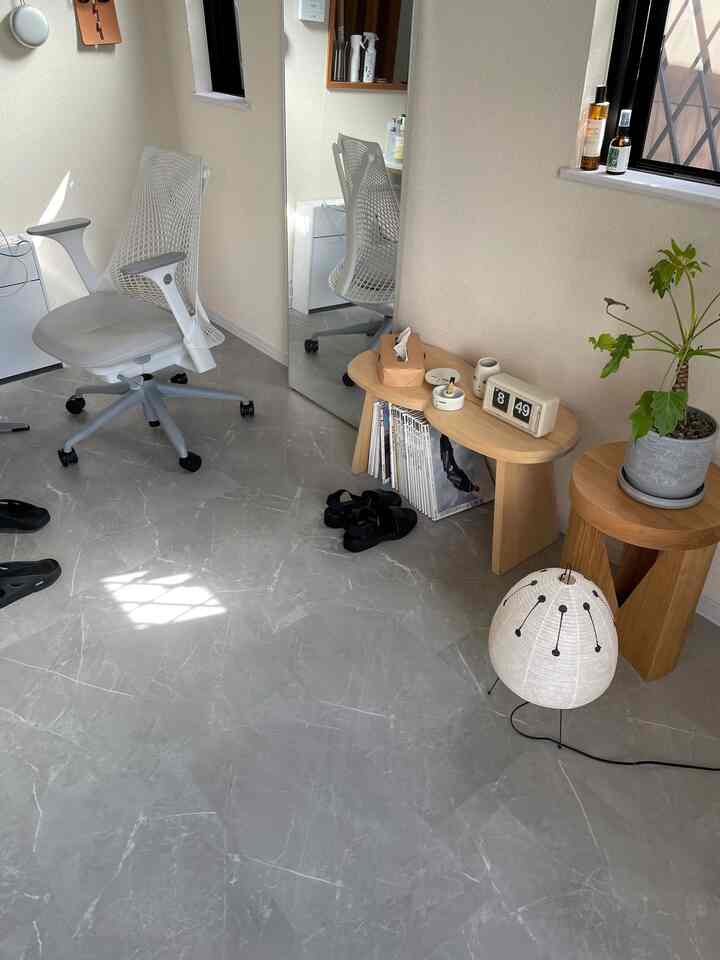 白とベージュの色調の狭い部屋、オフィスチェアと木製のテーブル、植物が配された雰囲気のあるホームオフィス