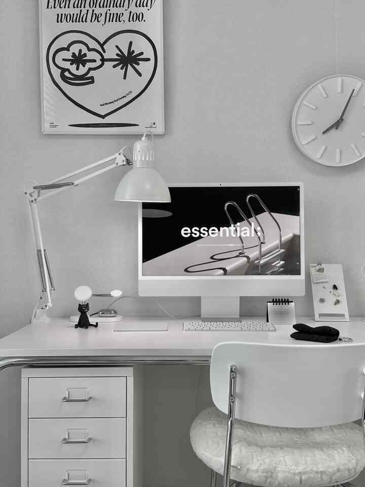 明るいグレー調のホームオフィス空間、白いデスクにモニターとデスクランプ、黒い猫のオブジェが配置されたシンプルな一人暮らし用デスク