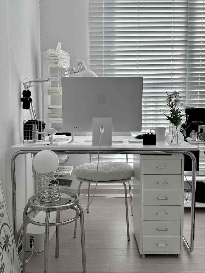 白とグレーのトーンのホームオフィス空間、中央にコンピューターと引き出しユニットが配置された清潔なデスク環境