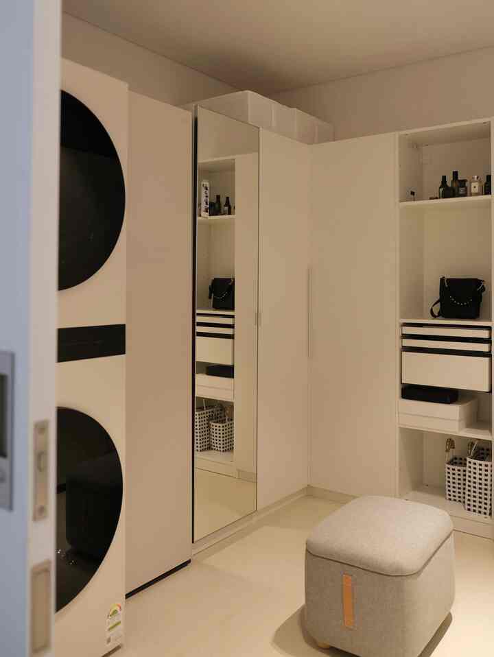 白とベージュのトーンが特徴のウォークインクローゼット、イケアのクローゼットと引き戸が配置された清潔感あるインテリア