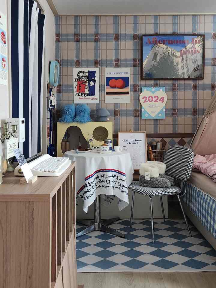 ブルーとベージュの色調が特徴の寝室、ポスターとホームカフェテーブルが配置された雰囲気のあるヴィンテージ風インテリア