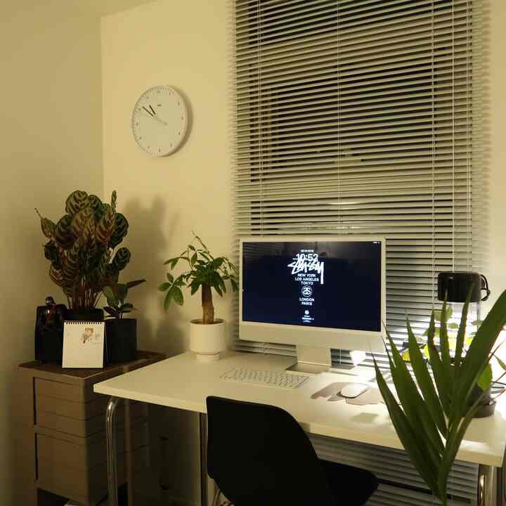 ホワイトとブラックの色調の書斎、iMacや机、複数の植物が配置された落ち着いた学習空間