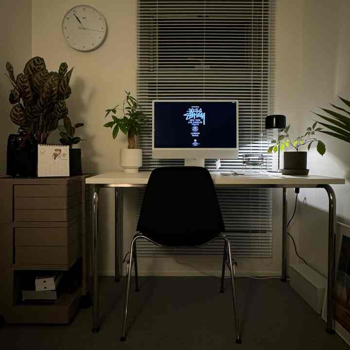 白と黒のトーンのホームオフィス、中央にパソコンが置かれたミニマルで清潔感のある作業空間