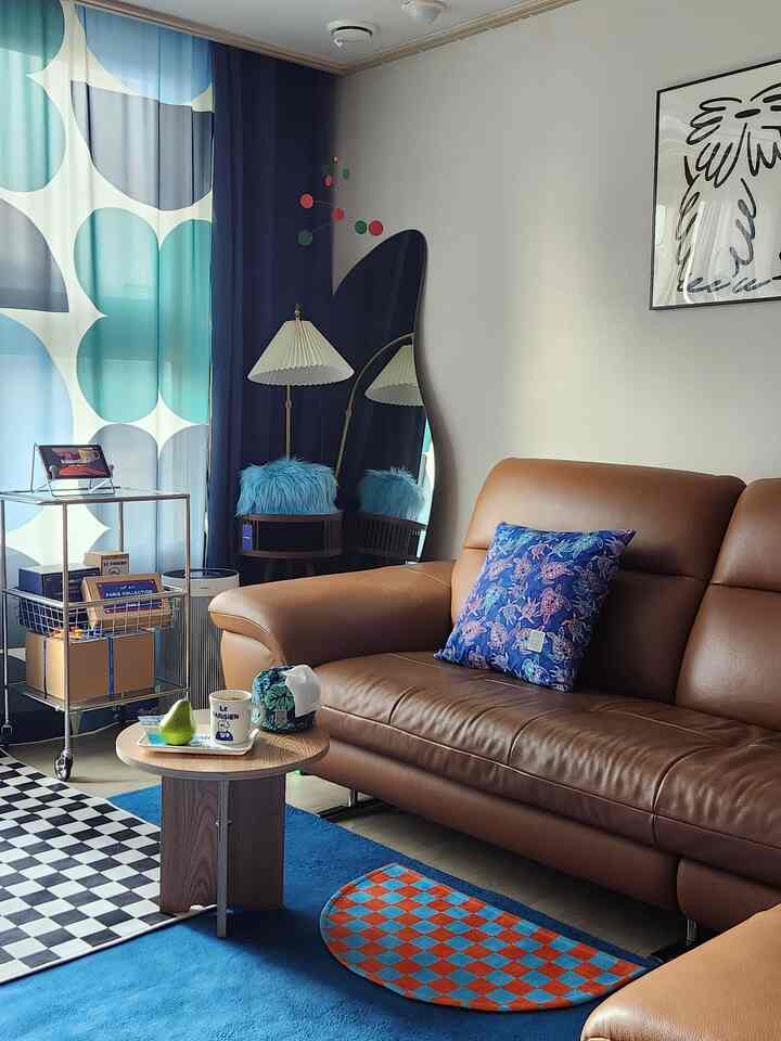 ブルーとブラウンのトーンが調和したカフェ風キッチン、ブラウンのソファと青いラグ、サイドテーブルが配置された雰囲気のあるインテリア