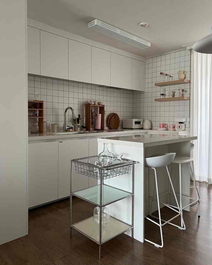 白と木目調を基調としたモダンなキッチン、すっきりとしたキッチンアイランドと収納アイデアが映えるインテリア