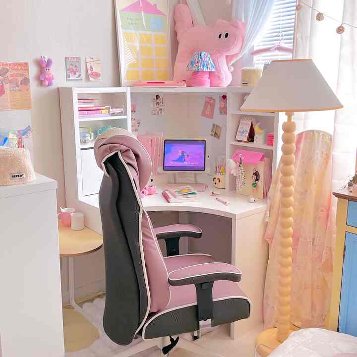 ピンクと白の落ち着いた色調のコンパクトなホームオフィス、コーナーデスクと快適なオフィスチェアが配置された雰囲気のあるインテリア