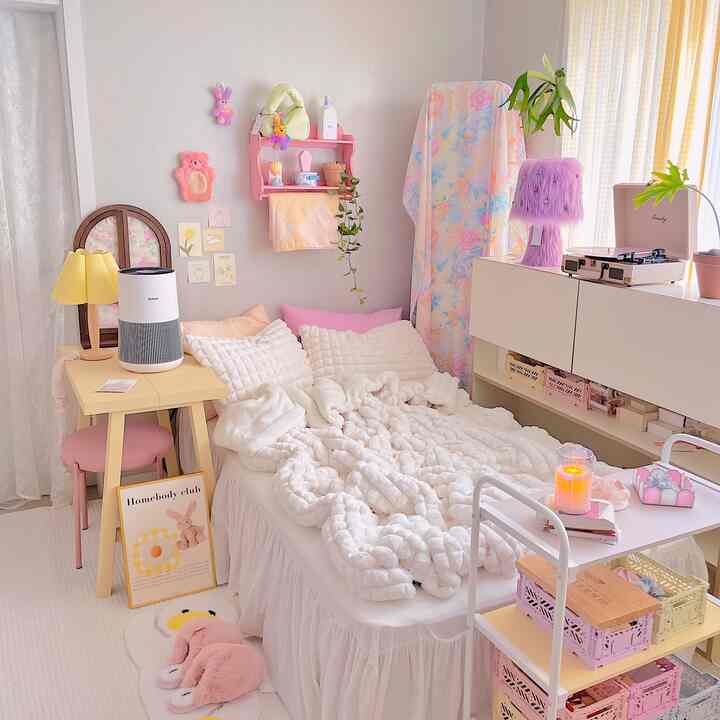 ピンクとホワイトの色調の赤ちゃんの寝室、柔らかな寝具とカラフルな収納が配置された雰囲気のあるインテリア