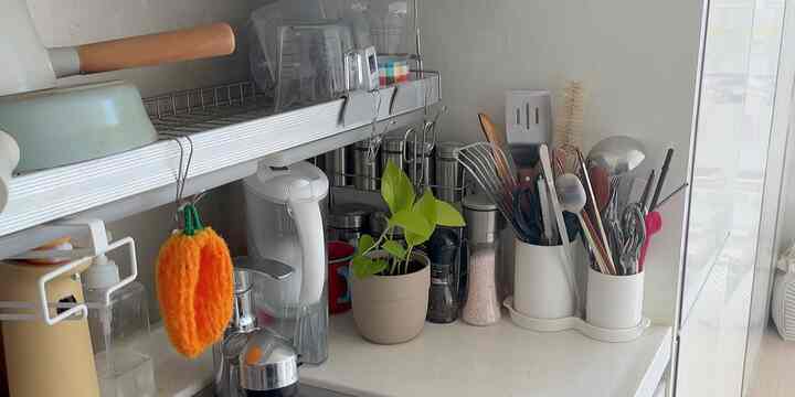 ホワイトトーンのキッチン、調理器具やピッチャー、キッチンタオルが整った清潔感のあるインテリア