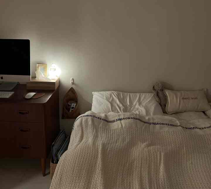 ナチュラルな色調の子供部屋、ベッドと木製のデスクが配置された温かみのある空間