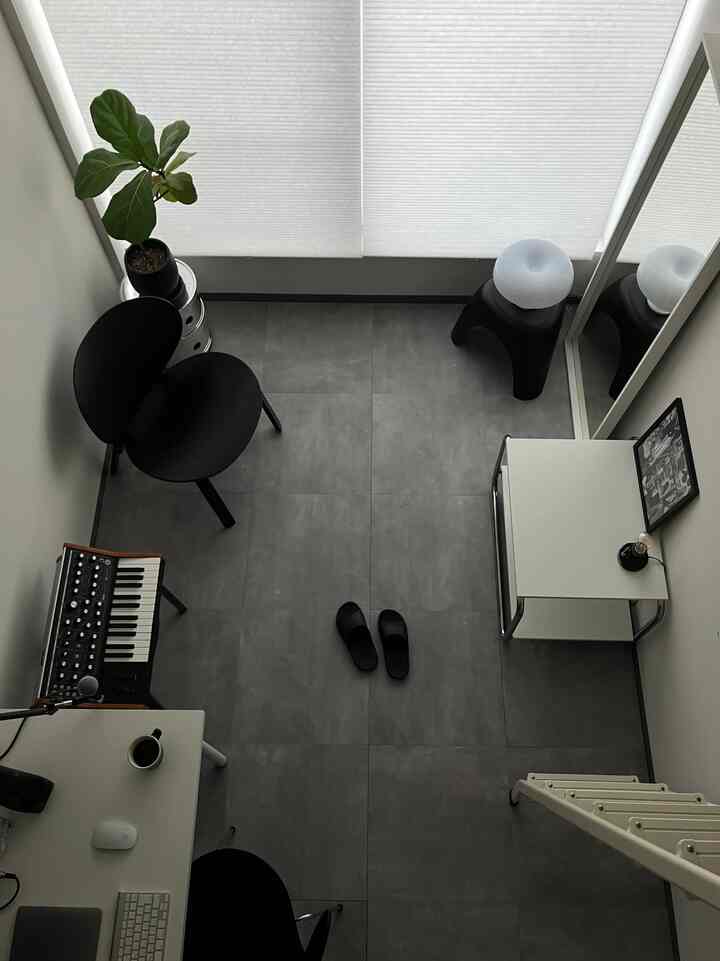 グレー調のコンパクトなモダンホームオフィス、ブラック家具と植物が配置されたシンプルなインテリア