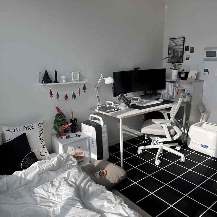 白と黒のトーンのワンルーム寝室兼ホームオフィス、シンプルで清潔感のある家具が配置された印象的な空間