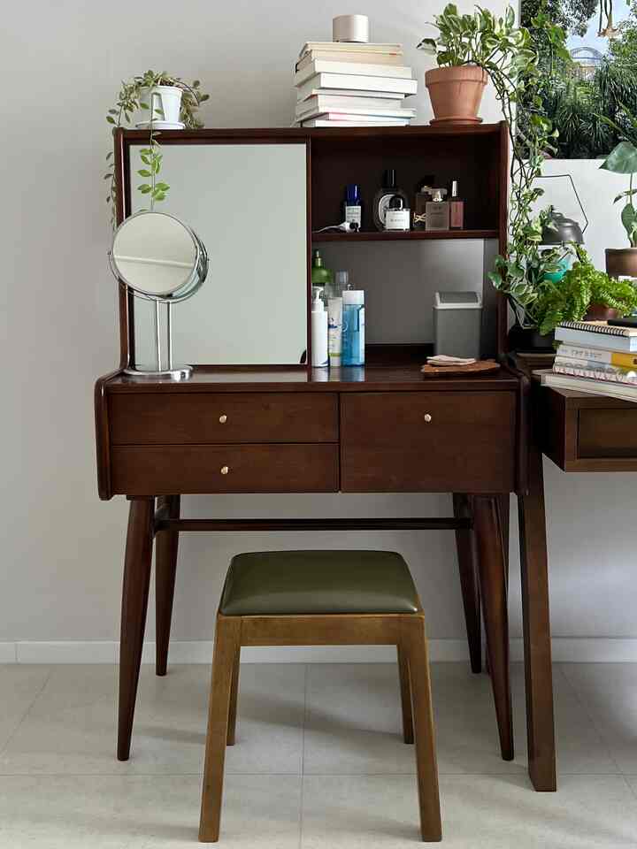 温かみのある木目調の化粧台と植物が置かれたシンプルな空間